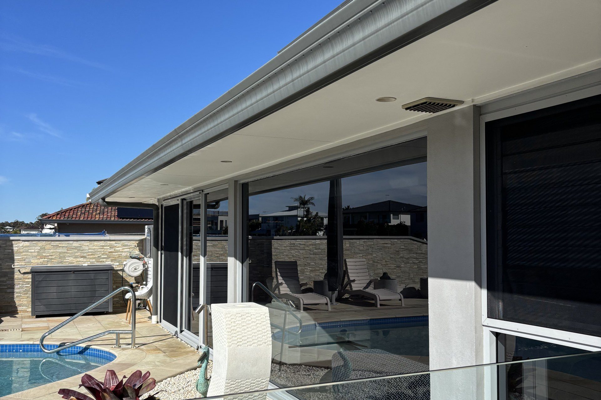 Freshly cleaned floor-to-ceiling windows on a modern poolside home
